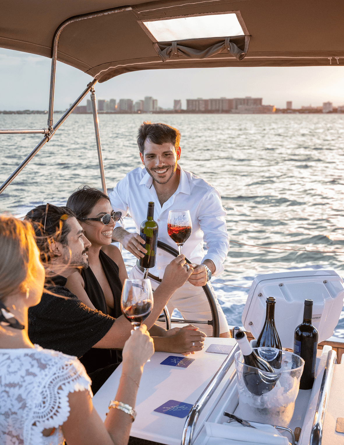 A sommelier presenting a bottle of red wine to guests aboard