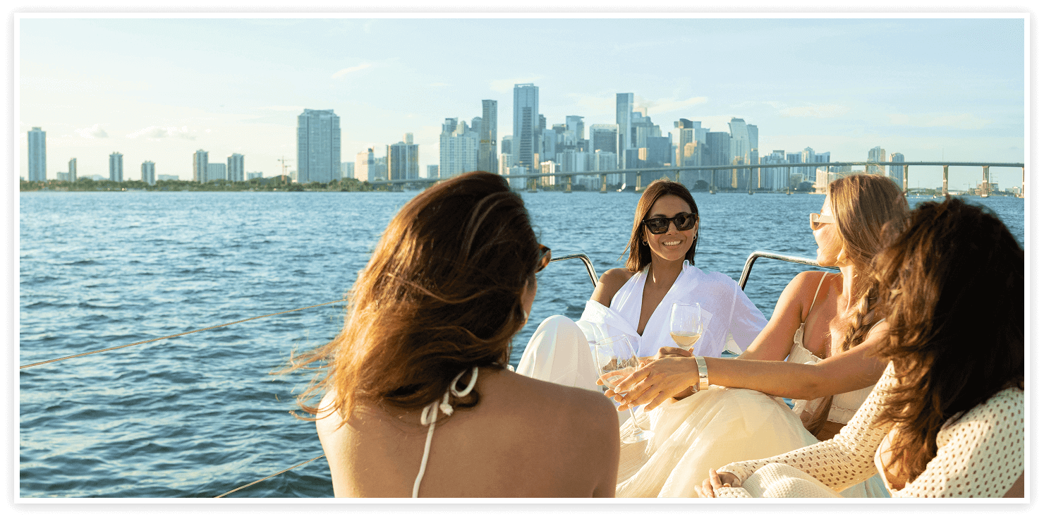 Guests on deck with the Miami skyline behind them