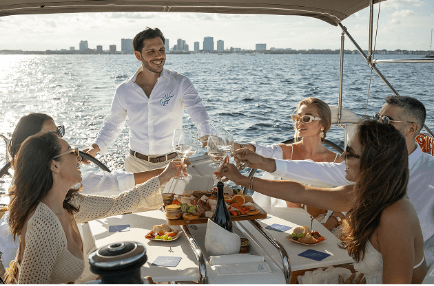 Guests toasting on deck beneath the bimini, Miami skyline behind