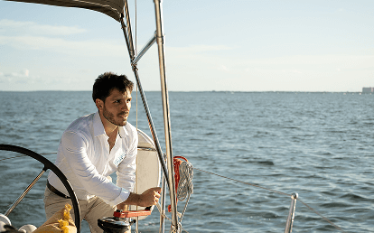 The captain at the helm steering the sailing yacht